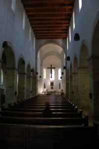 Eine Person sitzt in der Kirchenbank in einem gotischen Kirchenschiff zum Gebet