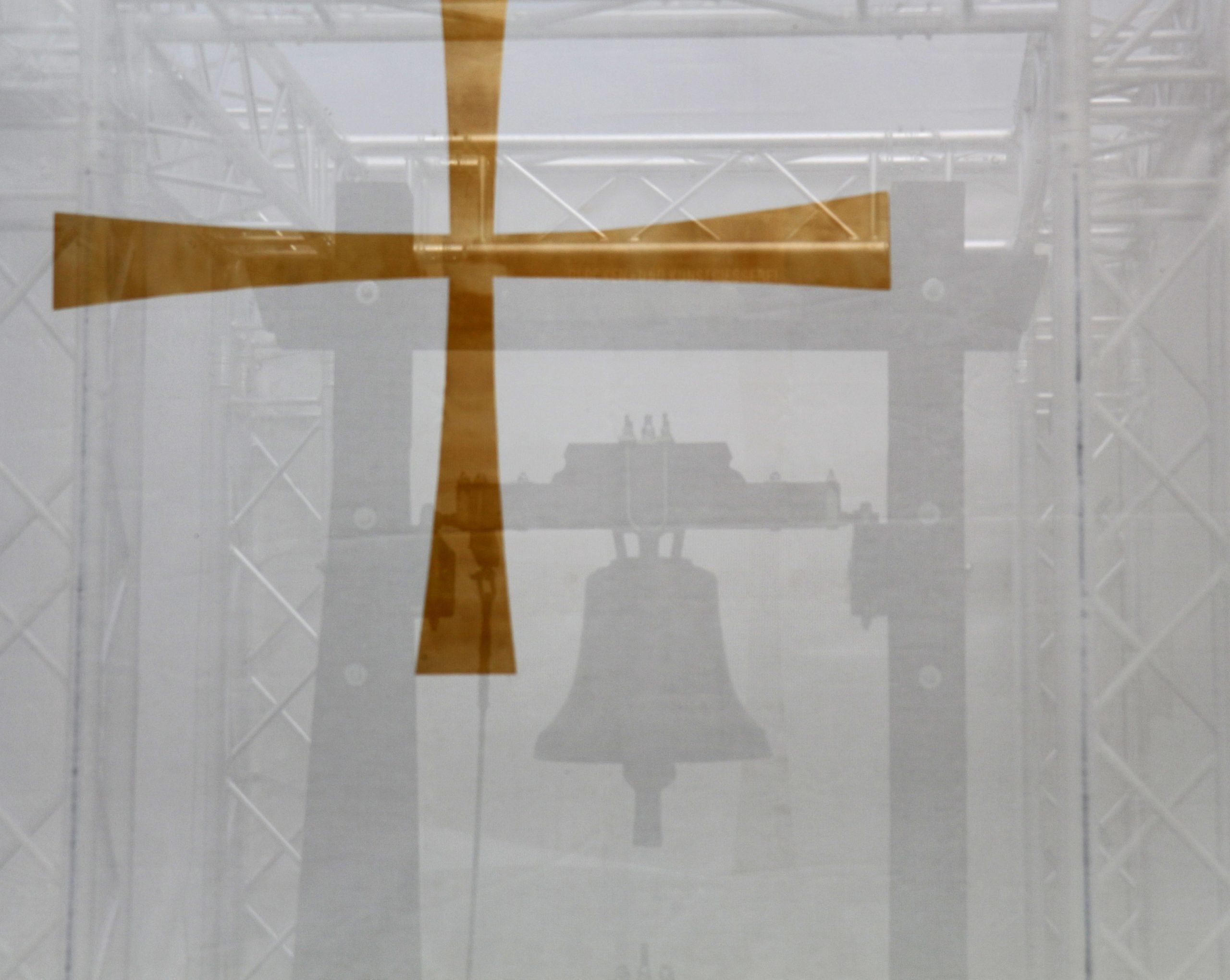 Eine Glocke und ein Kreuz im Vordergrund