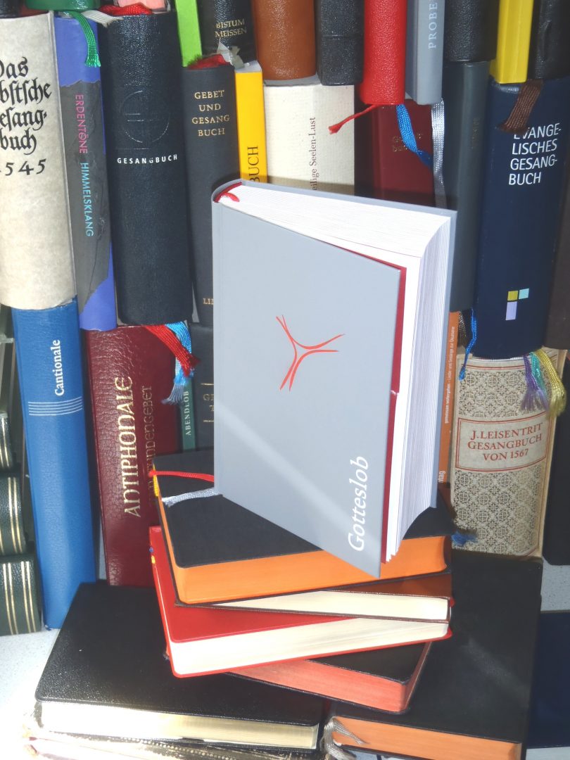 Verschiedene Gesangbücher stehen und liegen im Regal