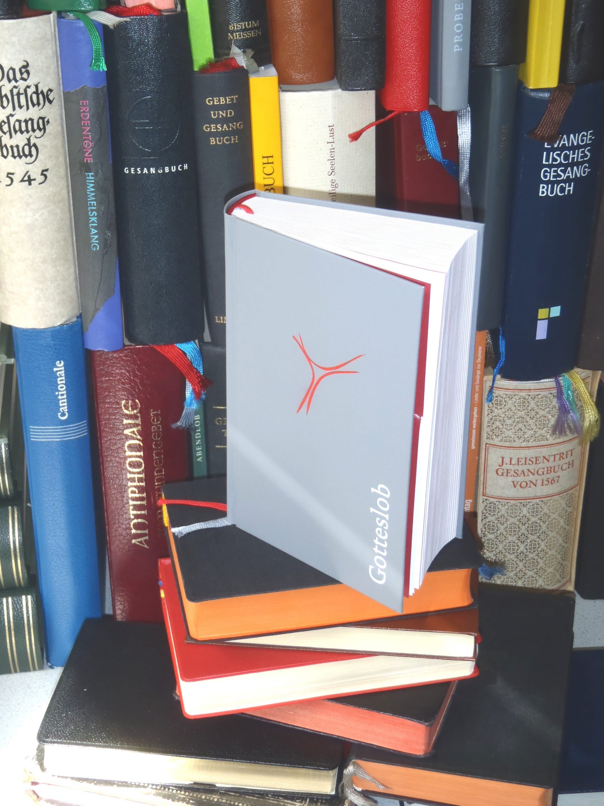 Verschiedene Gesangbücher stehen und liegen im Regal