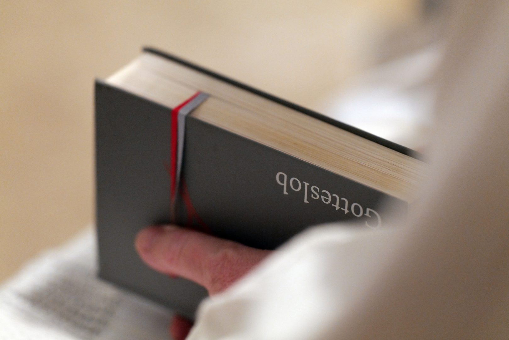 Ein geschlossenes Goteslob wird in den Haenden eines Scholasaengers