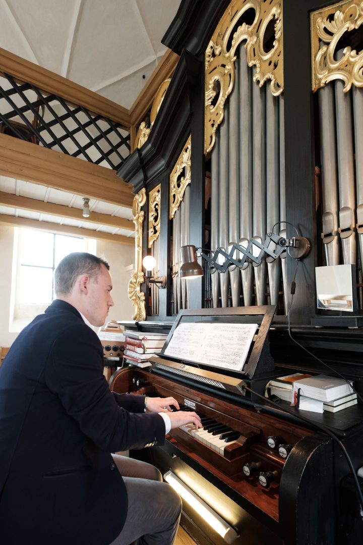 Ein Organist spielt an einer einmanualigen Orgel