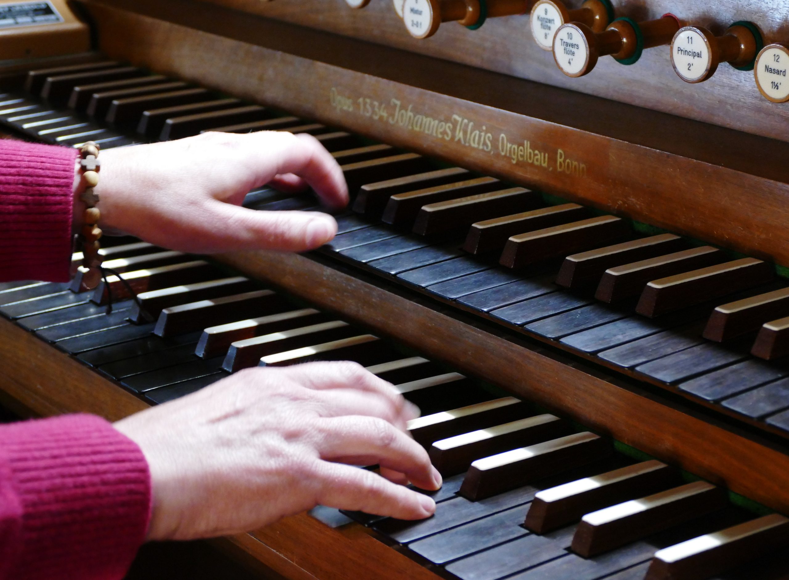 Eine Organistin spielt an einer zweimanualigen Orgel der Orgelbaufirma Klais