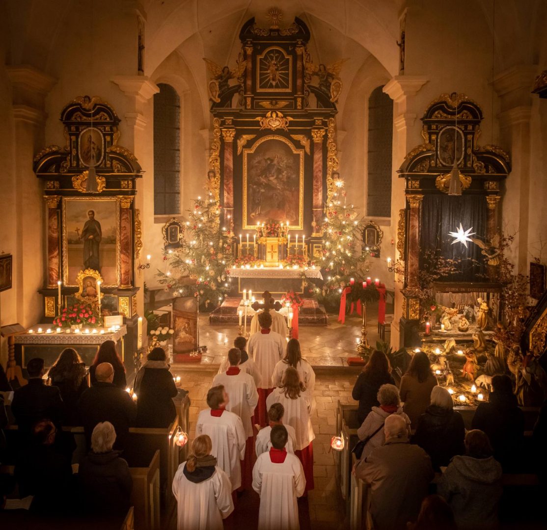 Christmette in einer von Kerzenlicht erleuchteten Kirche