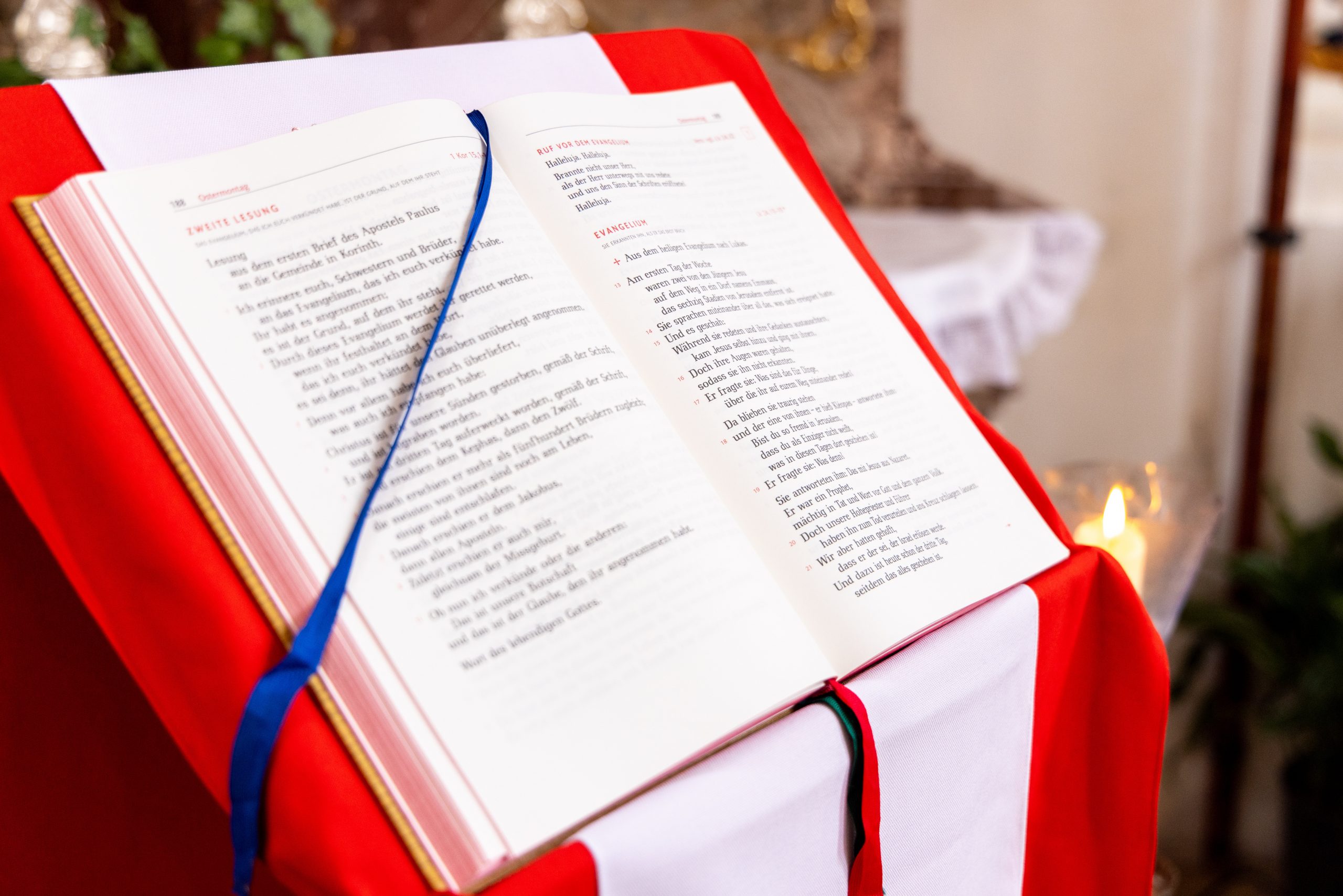 Ein Lektionar liegt aufgeschlagen auf einem Pult und zeigt das verkuendete Evangelium