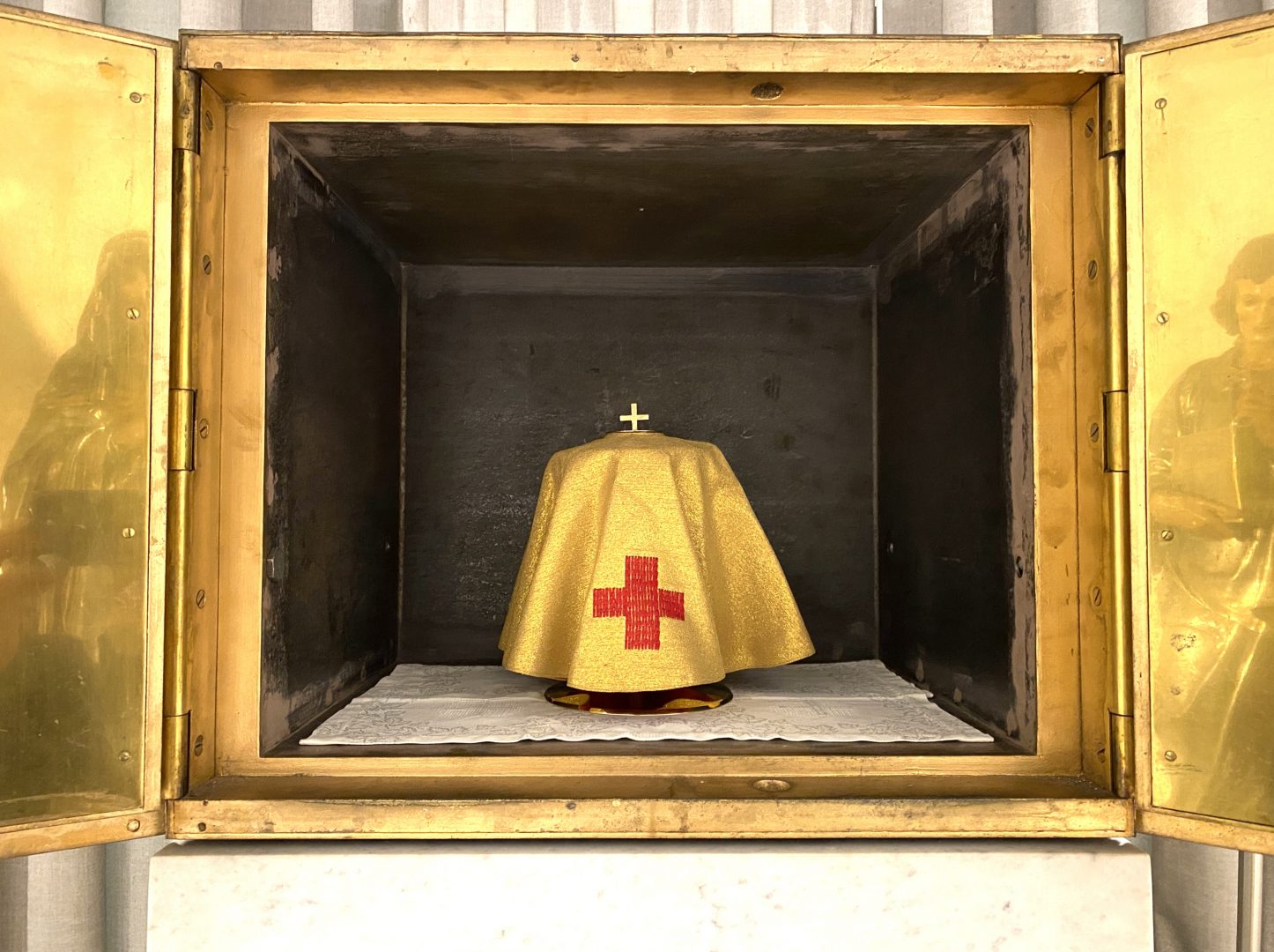 Ein Ziborium das mit einem goldenen Velum veruellt ist und in einem offenen Tabernakel steht